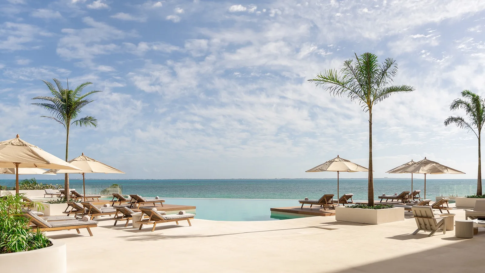 SHA Wellness Clinic, SHA Mexico: piscina infinita con tumbonas, sombrillas y palmeras frente al Caribe