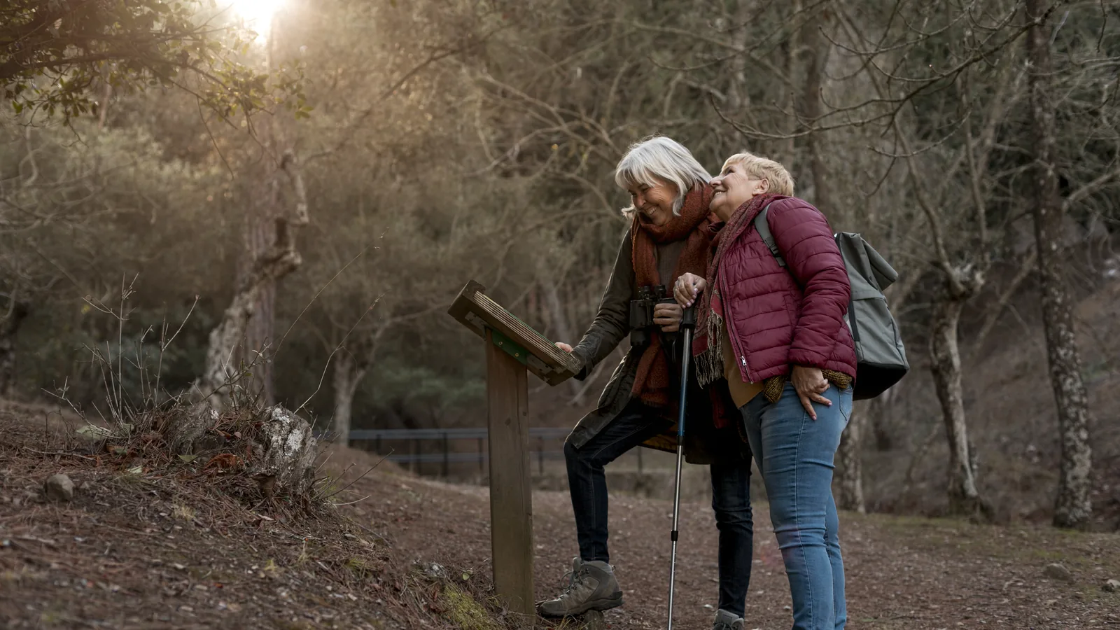 Dos mujeres mayores caminan por un sendero del bosque