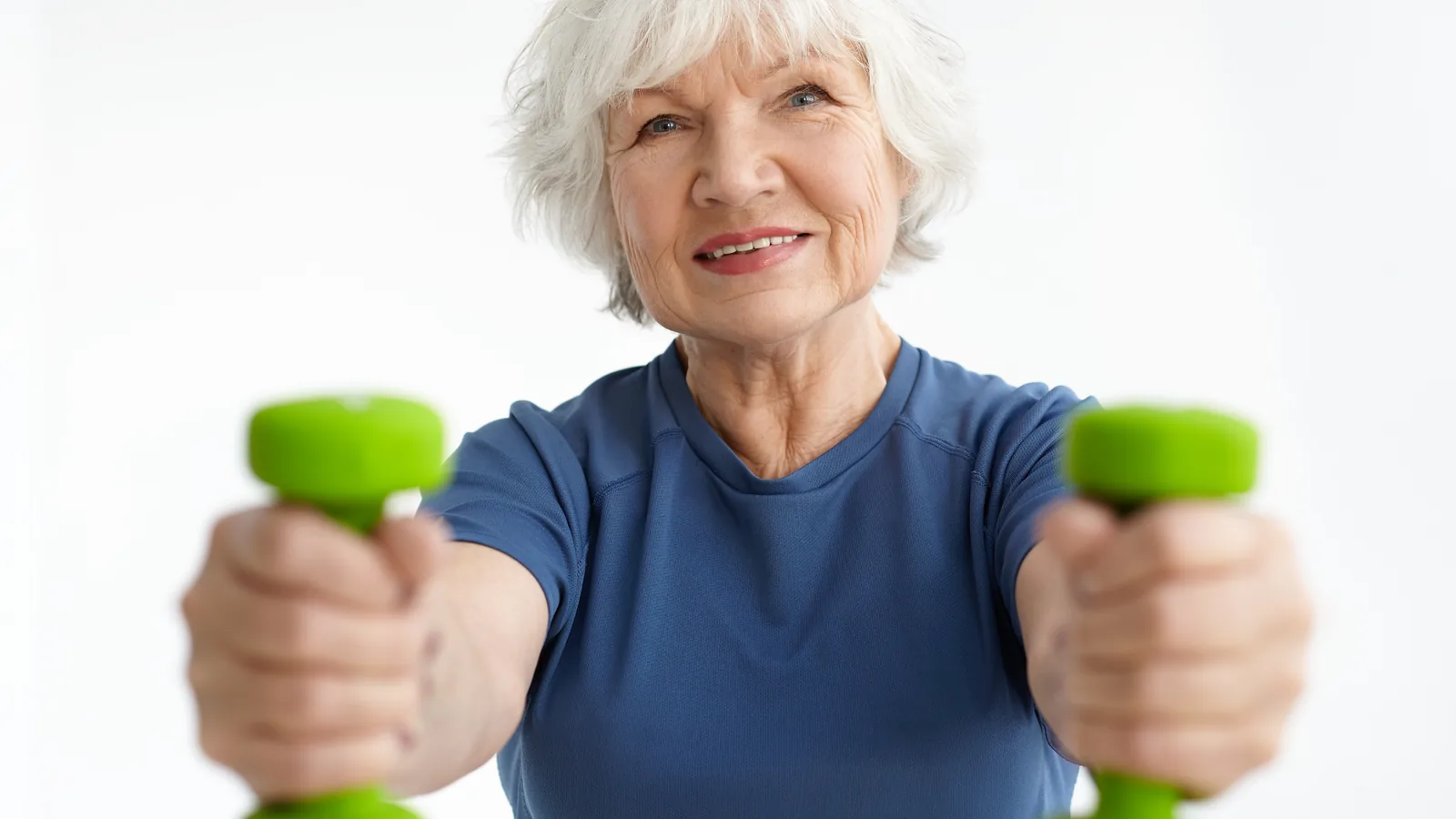 Mujer de sesenta y tantos entrena con mancuernas